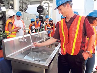 An engineer prepares to taste water from the reverse-osmosis pilot treatment system at an Orange County Water District plant.
