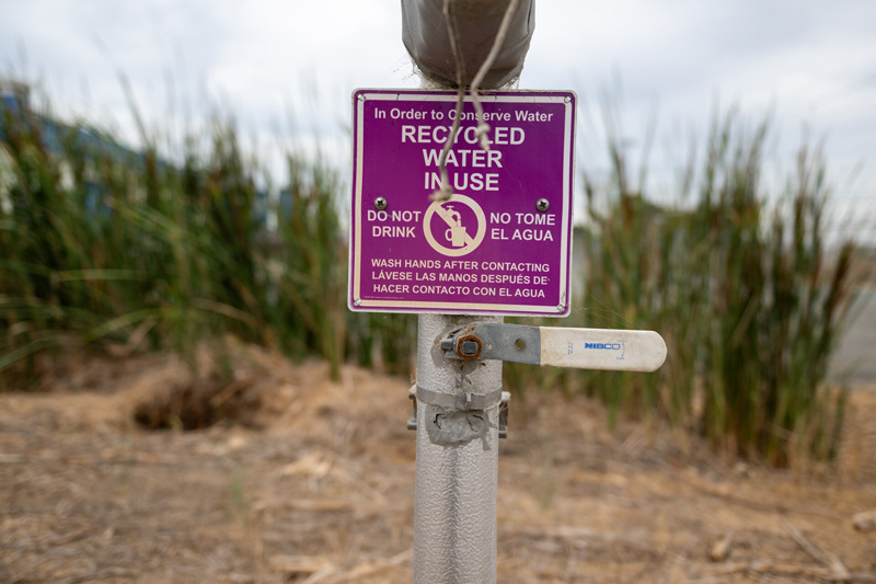 A sign says, ‘Recycled Water in Use’ outside of the Silicon Valley Advanced Water Purification Center in San José on Aug. 14, 2023. (Beth LaBerge/KQED)
